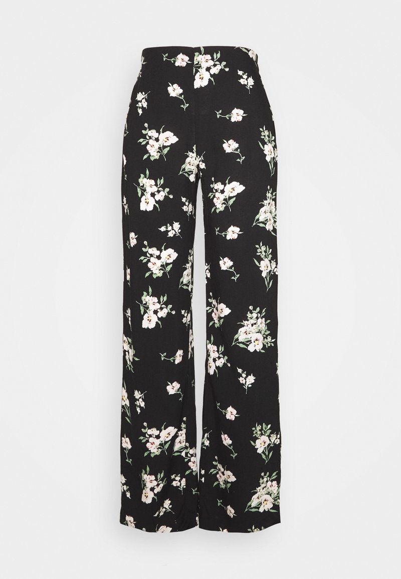 Pantalon large noir à fleurs, en tissu léger, avec une ceinture haute et un motif de fleurs blanches et roses avec des feuilles vertes.