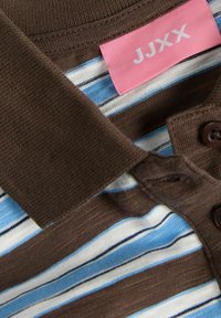 Brown collared shirt with blue and white horizontal stripes. Features a pink label with "JJXX" and two brown buttons on the collar.