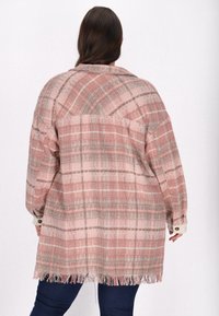 Cămașă supradimensionată în carouri roz și gri, cu margini desfăcute, manșete cu nasturi și o croială lejeră. Fabricată dintr-un material texturat.