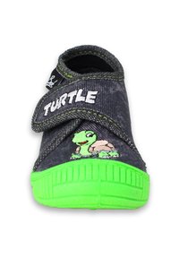 Donkergrijze schoen met een groene rubberen zool, met een schildpadontwerp en het woord "Schildpad" prominent weergegeven op de strap.