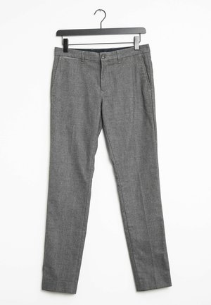 Graue maßgeschneiderte Hose mit Seitentaschen und Gürtelschlaufen, die an einem schwarzen Kleiderbügel vor weißem Hintergrund hängt.