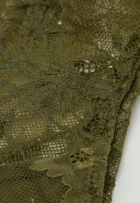 Olijfgroene kant stof met ingewikkelde bloemenpatronen en een netachtige textuur, met variërende draaddichtheden en een zachte val.