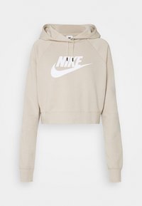 Felpa con cappuccio corta beige con tasca a marsupio frontale e cappuccio con coulisse. Presenta un grande logo Nike bianco sul petto. Tessuto morbido.