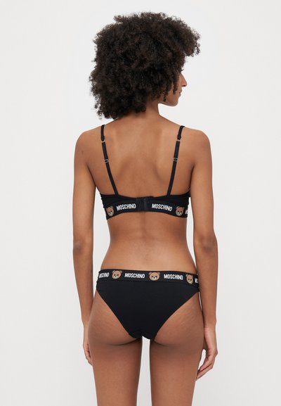 Čierna podprsenka a zodpovedajúci bikiny set vyrobený z jemnej tkaniny. Obsahuje nastaviteľné ramienka a pás s logom medvedíka.