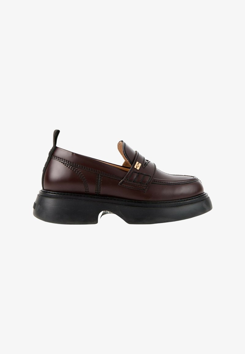 Mocassin en cuir marron foncé avec semelle noire épaisse, petit logo doré sur la bride et languette au talon, vu de côté.