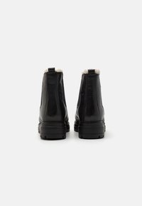 Bottes chevilles en cuir noir avec une finition lisse, semelles en caoutchouc et doublure en fausse fourrure au sommet pour plus de chaleur et de confort.