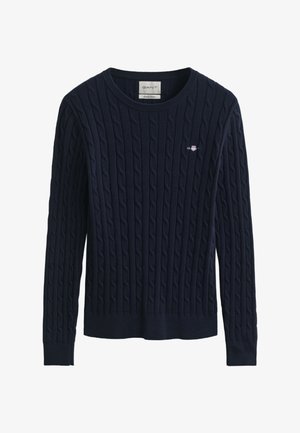 Tengerészkék kötött pulóver, fonott mintával, kerek nyakkivágással, bordázott mandzsettákkal és szegéllyel; a mellrészen kis hímzett logó.