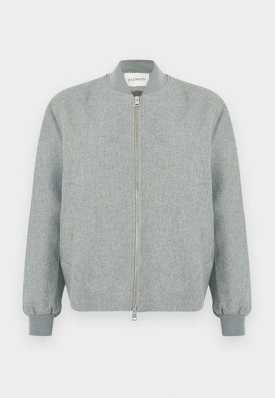 Veste bomber gris clair avec fermeture éclair frontale, col et poignets côtelés. Comprend deux poches latérales et une surface en tissu texturé.