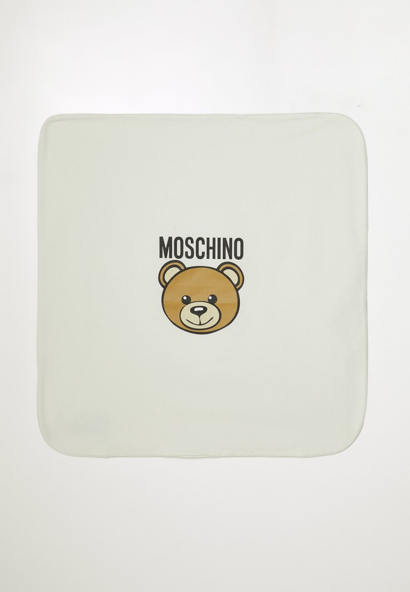 Šviesiai žalias audinio kvadratas su rudai ir juodai nupieštu animaciniu lokio veidu, virš kurio yra "MOSCHINO" užrašas. Tinkama tekstūra.