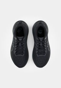 Black athletic shoes with a textured mesh upper, round toe, lace-up design, and a cushioned sole. Notable Asics branding at the heel and insole.