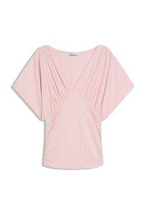 Blouse rose clair à manches courtes avec encolure en V profonde et détails froncés drapés sur le devant et les manches.