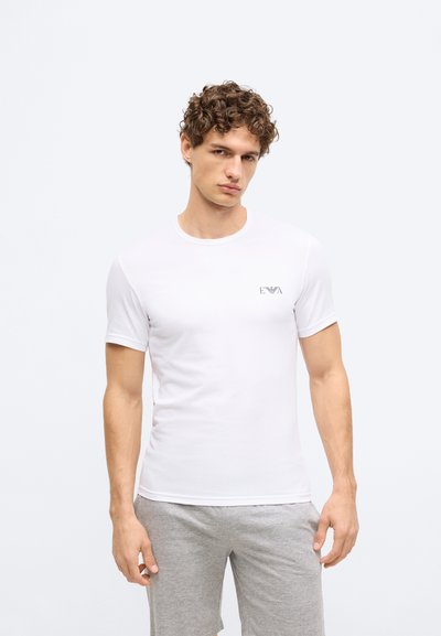 Balta īsroku kokvilnas T-krekls ar apaļu kaklu. Kreisajā krūtīs neliels melns logotips. Vienkāršs dizains, pieguļošs siluets.