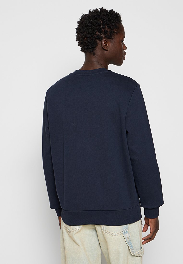 Felpa blu navy con colletto rotondo, maniche lunghe e polsini a costine. Realizzata in morbido cotone con una texture liscia.