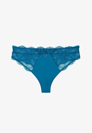 Tanga in pizzo verde acqua con un pannello solido esagonale nella parte anteriore. L'elastico in vita presenta un bordo a scallop e un dettaglio decorativo con anello metallico.