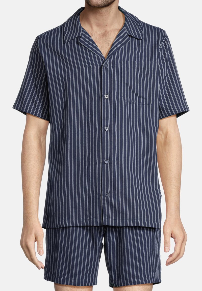 Korte mouwen marineblauw pyjama set met witte verticale strepen, bestaande uit een overhemd met knoopsluiting en een borstzak, en bijpassende shorts.