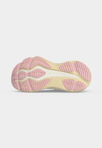 Σόλα από παπούτσι τρεξίματος Saucony με ροζ και μπεζ ελαστικό πέλμα και λευκή ενδιάμεση σόλα, σε προβολή από κάτω σε απλό φόντο.