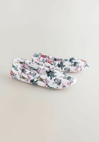 Valged kangast sussid, millel on mitmevärviline loomamustriga disain, ümara varbaosaga ja paindliku, siledapinnalise tekstuuriga.