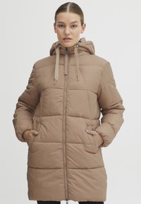 Beige puffer coat with a hood, featuring a central zipper, textured diamond quilt pattern, and side pockets for functionality.