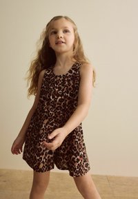 Haljina bez rukava s leopard uzorkom u smeđoj i crnoj boji, sa lepršavim krojem, okruglim izrezom i mekanom teksturom tkanine.