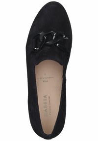Scarpa slip-on in suede nera con punta arrotondata e dettaglio decorativo in catena nera sulla parte superiore. Interno beige con marchio impresso.