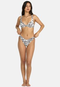 Bikini a fantasia bianco e nero con coppa triangolare e slip a vita bassa, realizzato in tessuto liscio e elasticizzato.