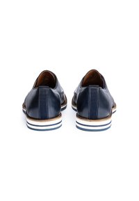 Paar dunkelblaue Lederschuhe mit weißen und blau gestreiften Sohlen, von hinten auf weißem Hintergrund gesehen.