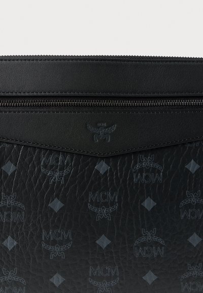Mala de mão em couro preto com logótipo em relevo e padrão de diamantes. Fecho com zíper, costura tonal e detalhes subtis em ferragens.