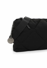 Black quilted bag with a textured surface, featuring a chain and fabric strap, and a metal tag with logo detail. Zipper closure at the top.