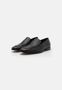 Black leather loafers with a smooth, rounded toe, minimalistic design, and a low stacked heel. No visible embellishments or patterns.