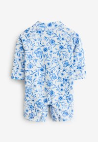 Bañador de manga corta con un patrón floral en diferentes tonalidades de azul sobre un fondo blanco. Cuenta con un cuello alto y un ajuste ceñido.