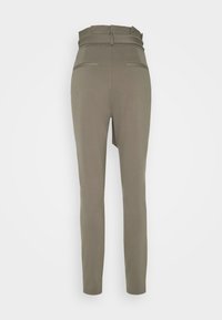 Pantalon slim taille haute couleur vert olive avec passants pour ceinture et deux poches passepoilées à l'arrière, présenté de dos sur un fond uni.