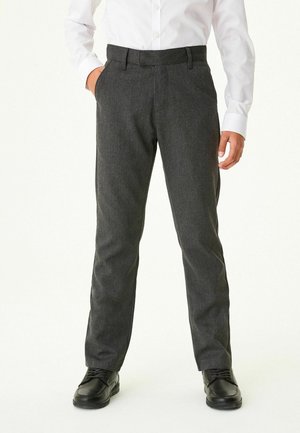 Pantalons en mélange de laine gris avec une coupe ajustée, présentant une taille plate, des poches latérales et une texture lisse. Associés à des chaussures noires.