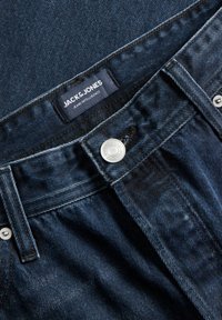 Σκούρα μπλε τζιν από denim με μεταλλικό κουμπί και ετικέτα Jack & Jones ραμμένη στην εσωτερική πλευρά της μέσης.