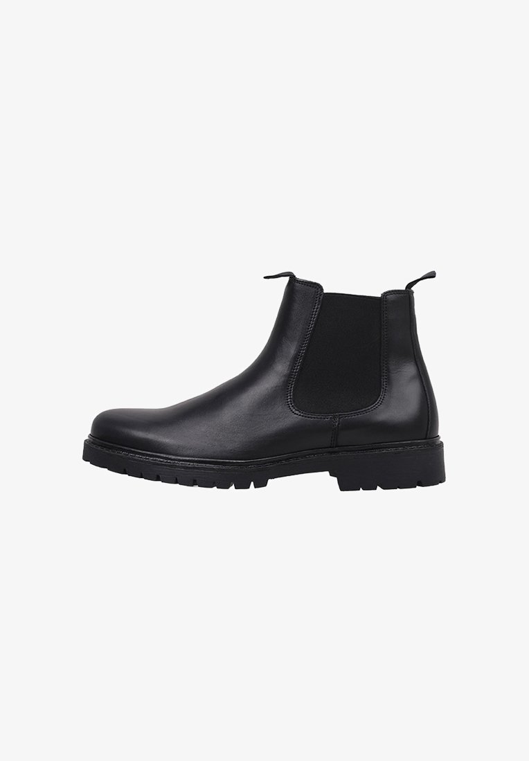 Bottines Chelsea en cuir noir avec panneaux latéraux en élastique, bout arrondi et semelle en caoutchouc épaisse et texturée pour plus de durabilité. Langettes sur le dessus pour un enfilage facile.