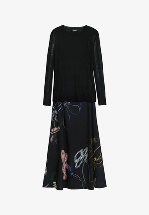 Musthave mustripsiga musta pikkade varrukatega kampsun, mis on kombineeritud suure multivärvilise abstraktse lillemustriga musta seelikuga.