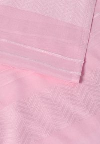 Lys rosa stof med et struktureret herringbone-mønster, med glatte, ensfarvede sektioner og en færdigkant. Blødt, let materiale.