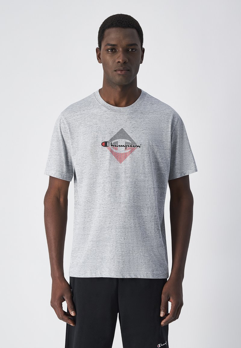 Camiseta gris de manga corta hecha de tela suave, con un gráfico de diamante en negro, rojo y blanco en el centro.