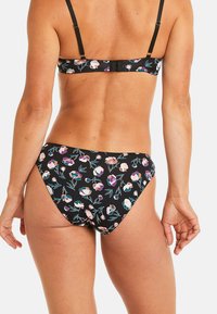 Ensemble de bikini floral avec un fond noir et des motifs de fleurs colorées. Bretelles ajustables, tissu doux et bas de maillot à couverture moyenne.