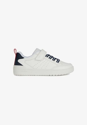 Baskets blanches avec des accents marine, avec une bande velcro et un laçage décoratif. Elles disposent d'une semelle texturée et d'un côté perforé pour la ventilation. Onglet de talon rouge.