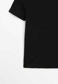 T-shirt nera a maniche corte con costine, caratterizzata da un orlo dritto e un tessuto morbido e texturizzato, senza loghi visibili o decorazioni aggiuntive.