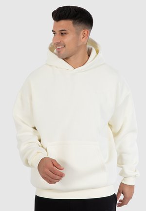 Crème-kleurige hoodie van zacht materiaal, met een voorzak, ribgebreide manchetten en een trekkoord-capuchon. Glad van textuur, ontspannen pasvorm.