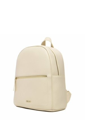 Beżowy skórzany plecak ze złotymi detalami na zamku błyskawicznym, przednią kieszenią i górnym uchwytem, pokazany na białym tle.