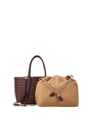 Barna szőtt kézitáska fonott fogantyúval és bézs, bőrvéggel ellátott zsinórzattal ellátott zsák táska, egymás mellett fehér háttéren.