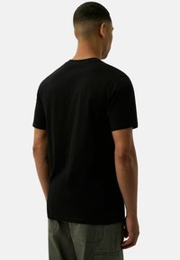 Czarna koszulka z krótkim rękawem, wykonana z miękkiego materiału, z klasycznym okrągłym dekoltem i prostym wzorem. Widoczne szwy i gładka faktura.