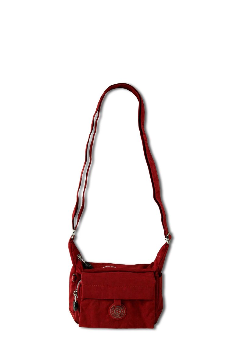 Red crossbody bag made of soft fabric with a front flap, zippered compartments, and an adjustable strap. Features a circular logo detail.