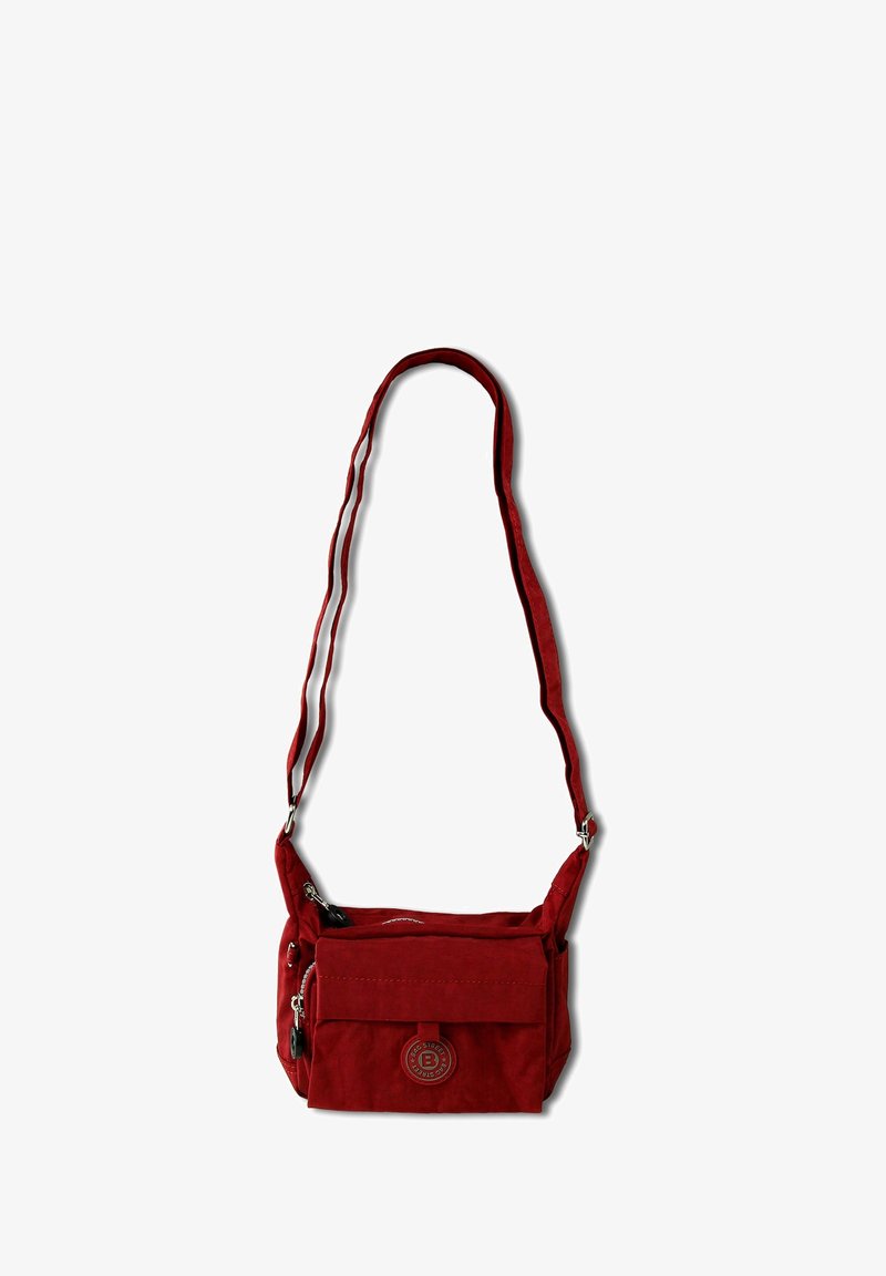 Sac bandoulière rouge en tissu doux avec un rabat avant, des compartiments zippés et une sangle ajustable. Présente un détail de logo circulaire.