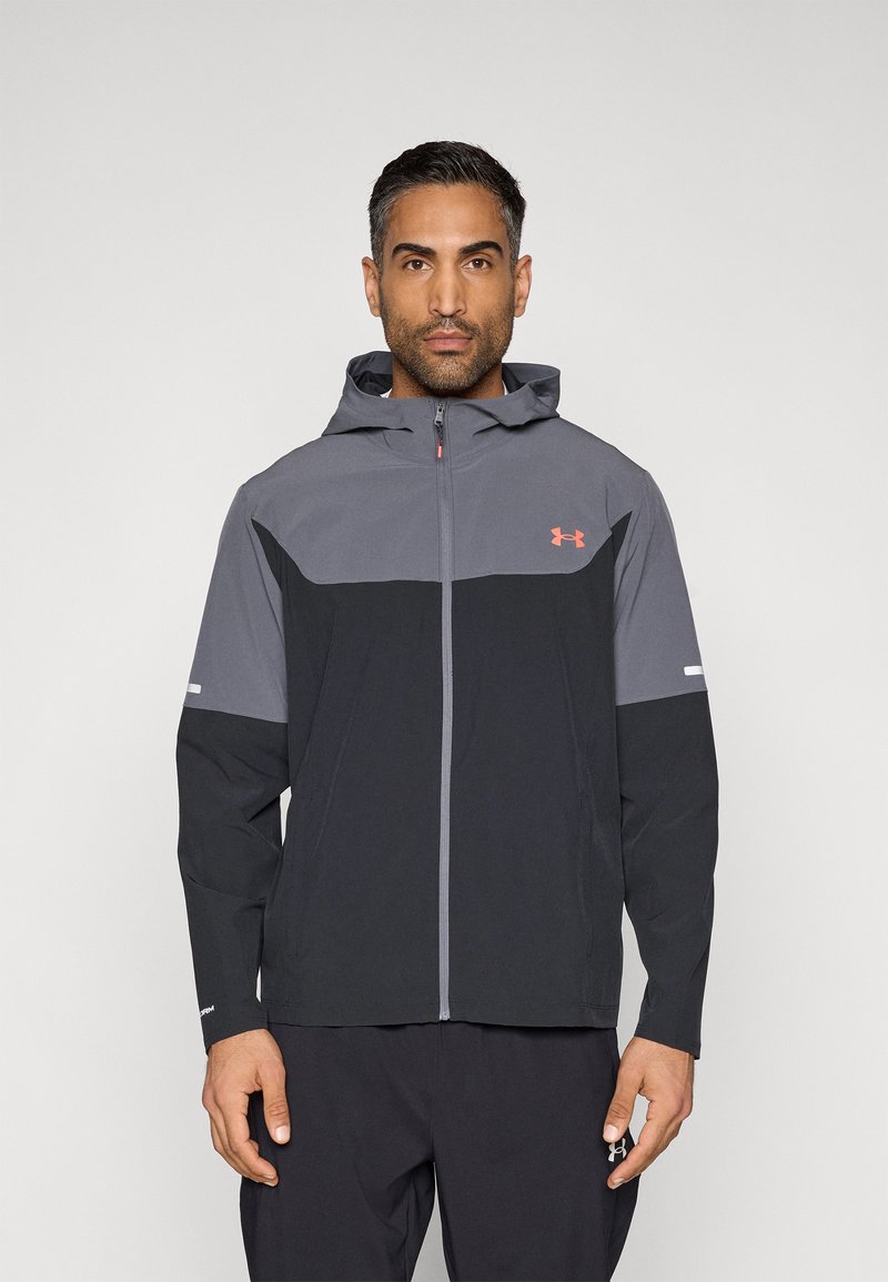 Μαύρο και γκρι μπουφάν με κουκούλα και φερμουάρ, με σχεδιασμό σε μπλοκ χρωμάτων, ανακλαστικές λεπτομέρειες στα μανίκια και λογότυπο Under Armour.