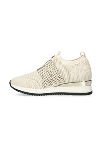 Beige stickad slip-on sneaker med metalliska nubb, dragflikar vid hälen och tungan, vit mellansula, svart zigzag yttersula och metallisk hälaccent.