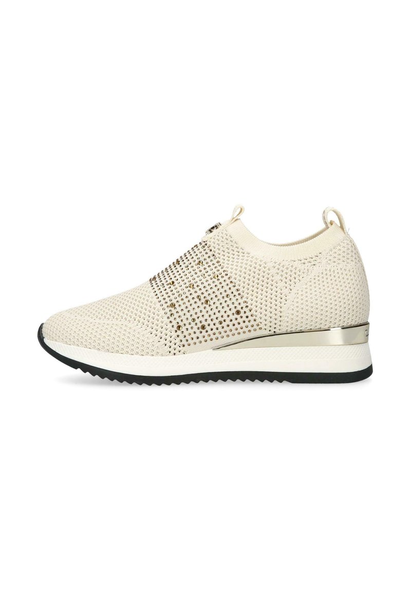 Beige stickad slip-on sneaker med metalliska nubb, dragflikar vid hälen och tungan, vit mellansula, svart zigzag yttersula och metallisk hälaccent.