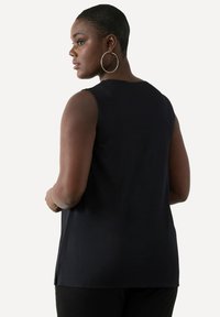 Czarna bezrękawnik z okrągłym dekoltem, gładką fakturą i bocznymi rozcięciami. Charakteryzuje się luźnym krojem, odpowiednim do codziennego noszenia.